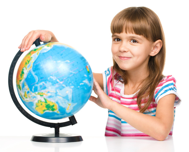 Little girl is examining globe - Фото, изображение