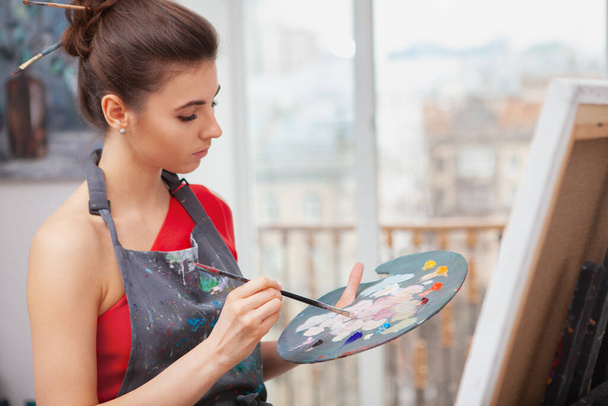 Cropped shto of an attractive young woman mixing paint on her palette while painting in art class - Foto, imagen