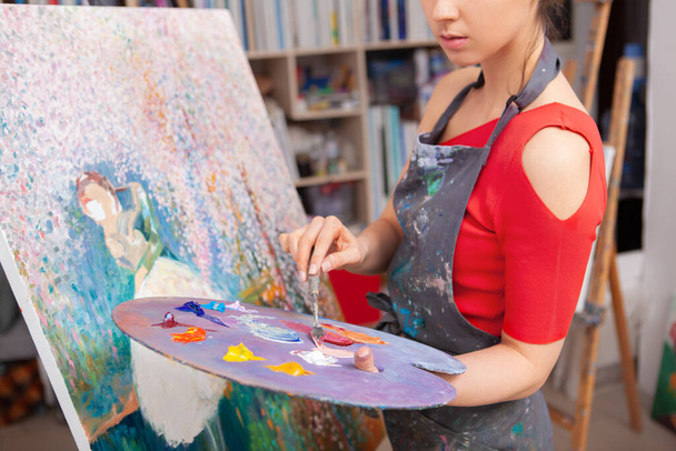 Cropped shot of a female artist mixing oil paint on a palette. Inspiration, creativity concept - Fotó, kép