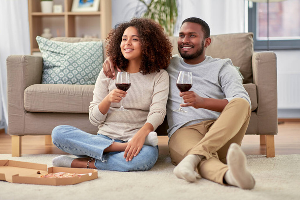 happy couple with wine and takeaway pizza at home - Zdjęcie, obraz
