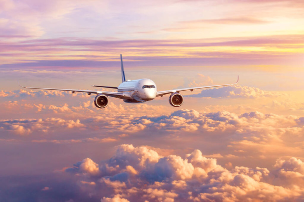 Repülőgép repülőgép repülőgép repül át gyönyörű esti felhők, az égen naplementekor - Fotó, kép