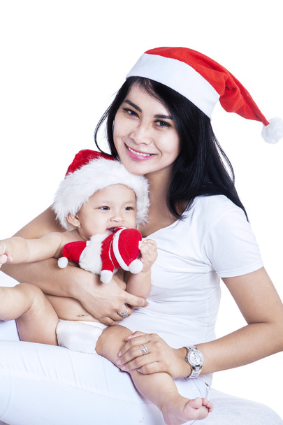 Happy mother and baby in red Christmas hats - Foto, Bild