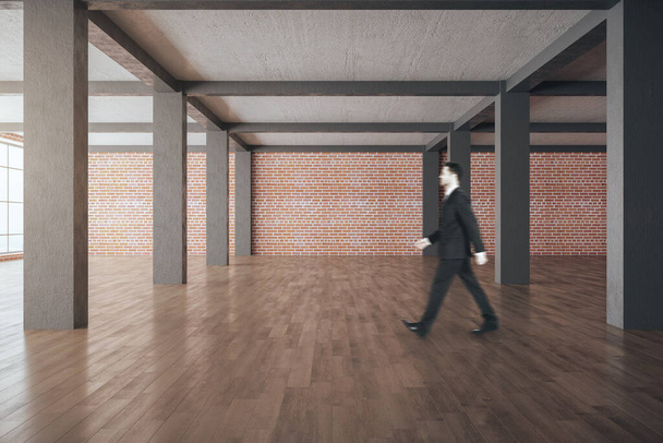 Empresario caminando en el interior de la galería moderna con paredes y columnas vacías. Prepárate.
, - Foto, imagen