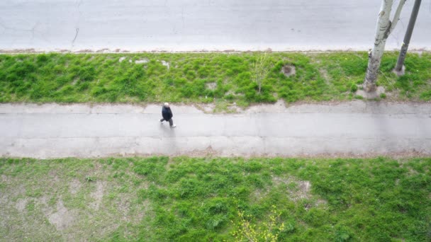 Een man die over de weg loopt, een uitzicht van boven. - Video