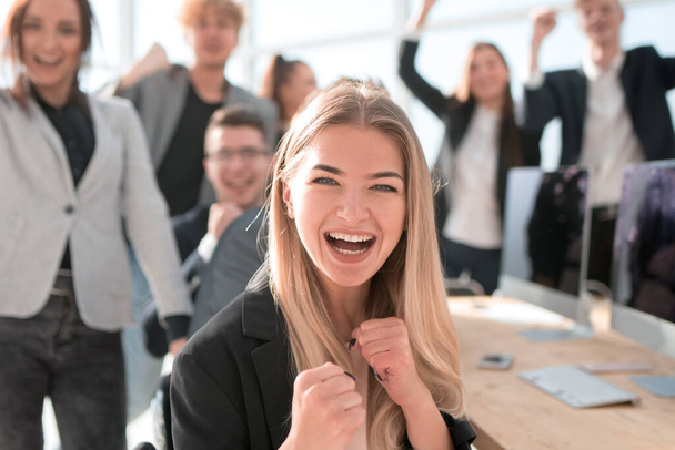 young woman on the background of a jubilant business team. - Foto, imagen