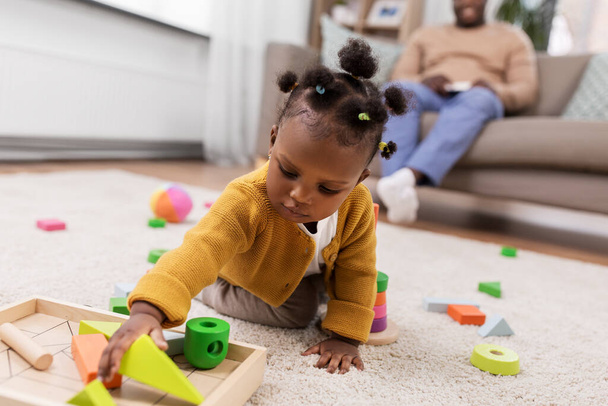 Afrikanisches Mädchen spielt zu Hause mit Spielzeugklötzen - Foto, Bild
