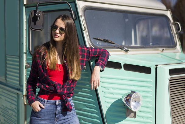 Smiling pretty young woman standing by the vintage minivan - Photo, Image