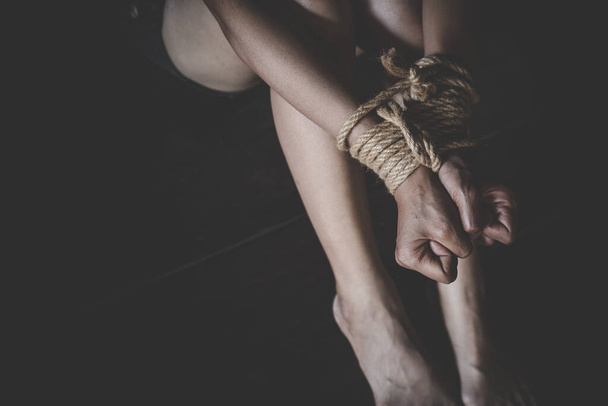 Porwana kobieta związana liną, maltretowana, zakładniczka, cierpiąca kobieta, handel ludźmi, prawa człowieka. - Zdjęcie, obraz