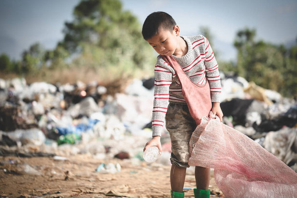 Arme kinderen verzamelen afval voor verkoop en recyclen het op stortplaatsen, het leven en de levensstijl van de armen, kinderarbeid, armoede en milieu Concepten - Foto, afbeelding