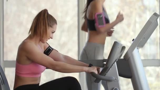 Mujer bastante joven usando la cinta de correr en el gimnasio moderno
  - Metraje, vídeo