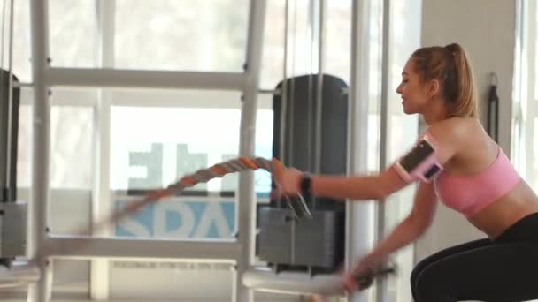 Όμορφη νεαρή γυναίκα που εξασκείται με σχοινιά μάχης στο γυμναστήριο - Πλάνα, βίντεο
