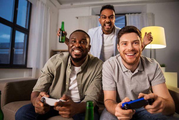 happy friends playing video games at home at night - Φωτογραφία, εικόνα