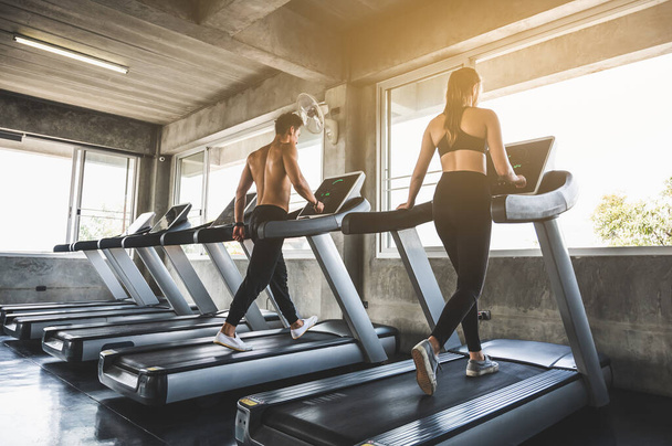 Man and woman Exercising by running on the treadmill To maintain good health always - Foto, imagen