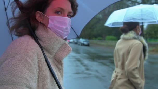 Handheld tiro em câmera lenta de duas mulheres que atravessam a rua enquanto vestindo máscaras protetoras em público
 - Filmagem, Vídeo