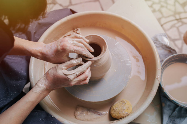 closeup of hands potter master creating a bowl of clay on a potter's wheel.  - Foto, afbeelding