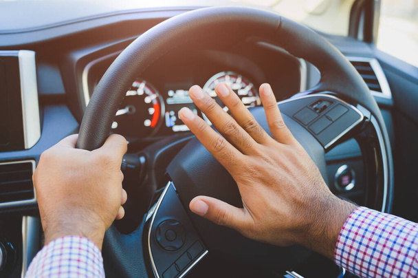 Χέρι άνθρωπος πιέζει κέρατο αυτοκινήτου κατά την οδήγηση του αυτοκινήτου. - Φωτογραφία, εικόνα