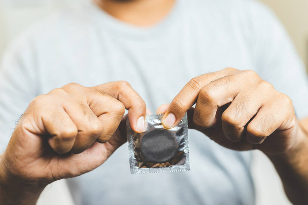 Mano masculina sosteniendo condón. Concepto de sexo seguro
. - Foto, imagen