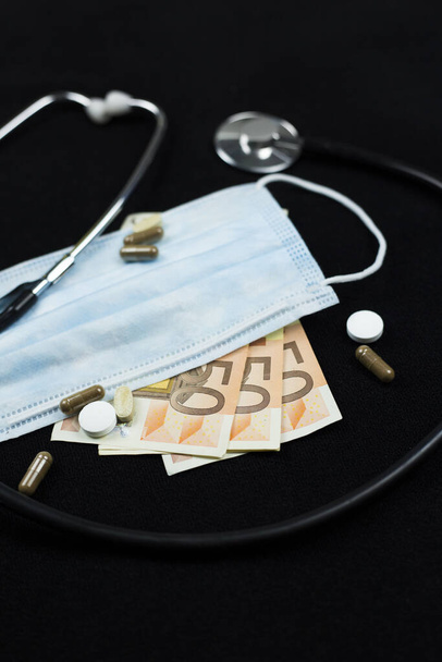  Health Care Industry concept. Top view of the doctors instruments and euro money, isolated on black. - Photo, Image