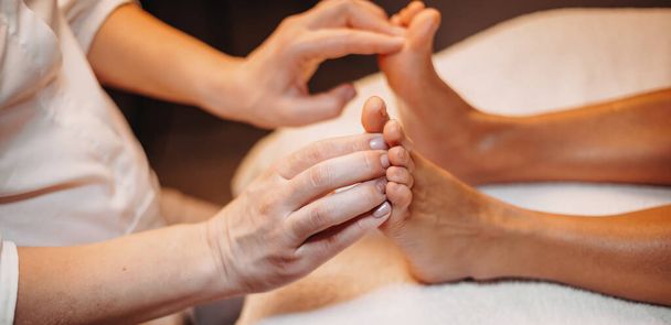 Sessão de massagem nas pernas com mulher caucasiana deitada no sofá no salão de spa
 - Foto, Imagem