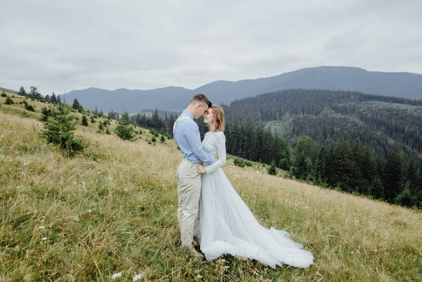 Photoshoot of the bride and groom in the mountains. Boho style wedding photo. - Фото, зображення