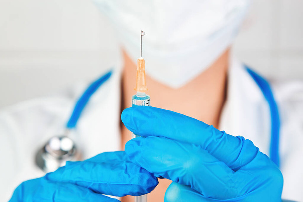 Close-up portrait of a healthcare professional preparing an injection - Foto, imagen
