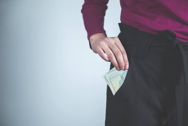 man hand money on pocket on grey background - Фото, зображення