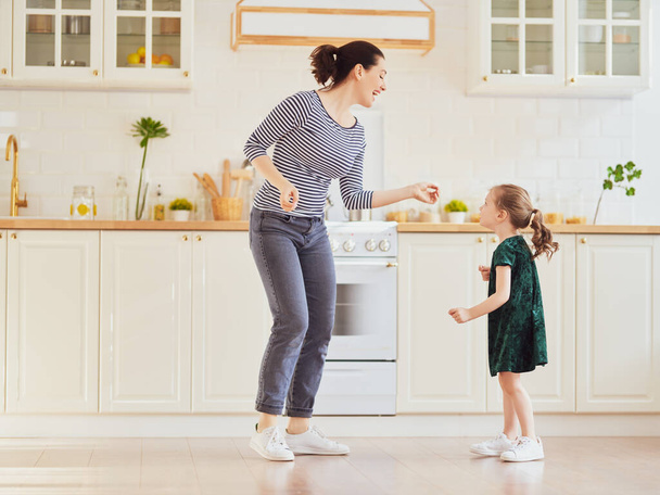 Happy mother's day! Child daughter and mom cooking and having fun in the kitchen at home. Family holiday and togetherness. - Фото, зображення