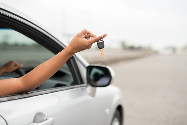 Männliche Hand hält Autoschlüssel, während sie im Auto sitzt, für neues Fahrzeugkonzept. - Foto, Bild