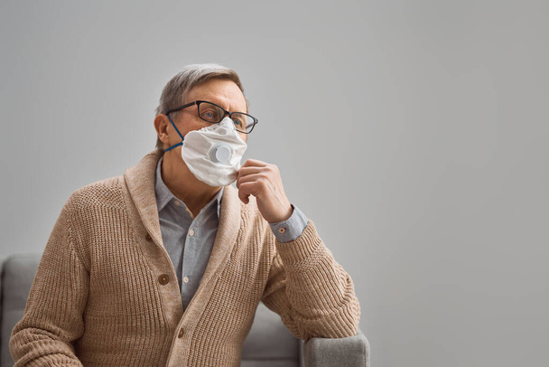 Old man wearing facemask during coronavirus and flu outbreak. Virus and illness protection, home quarantine. COVID-2019 - Zdjęcie, obraz