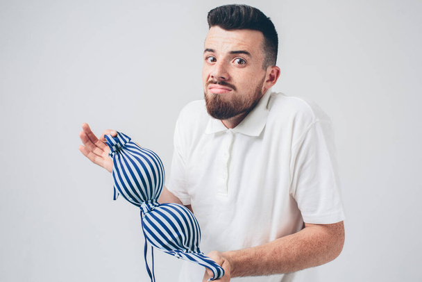 somebodys underwear near your husband. man holding a womans bra - Photo, Image