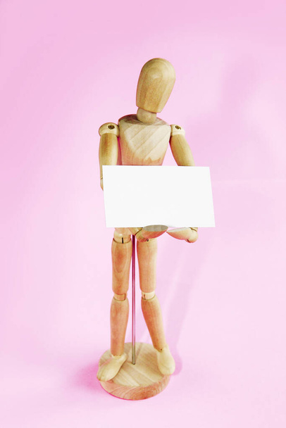 mannequin en bois tenant plaque publicitaire cadre blanc
 - Photo, image