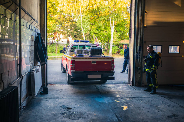 Пожарная машина покидает гараж пожарной охраны
 - Фото, изображение