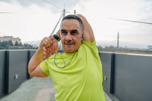Jól megépített érett futó öltözött fitness viselet készül a futás - Fotó, kép