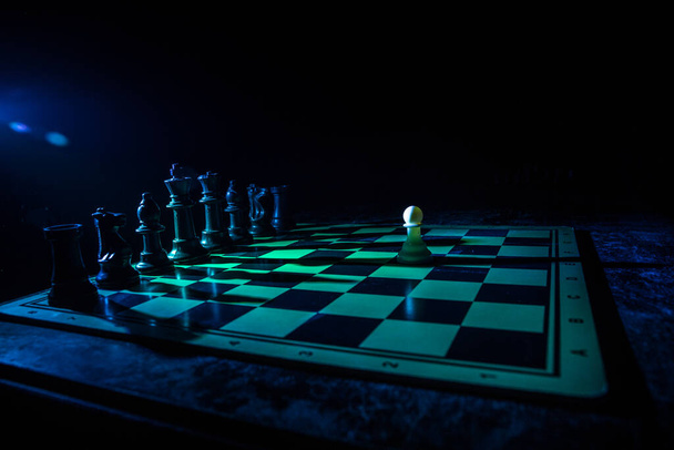 Conceito de jogo de tabuleiro de xadrez de ideias de negócios e competição. Figuras de xadrez em um fundo escuro com fumaça e nevoeiro. Foco seletivo
 - Foto, Imagem