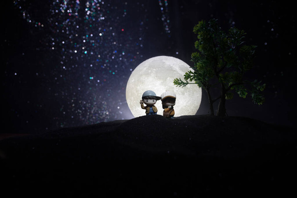 Egy csillagos és holdfényes hátterű pár sziluettjei. Boldog meleg pár éjszaka holdfényben. Kreatív műtárgytábla dekoráció. - Fotó, kép