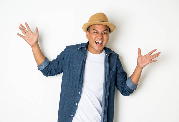 Азиатские мужчины в возрасте около 30 лет носят шляпы и джинсы. Стоять и радостно смеяться
 - Фото, изображение