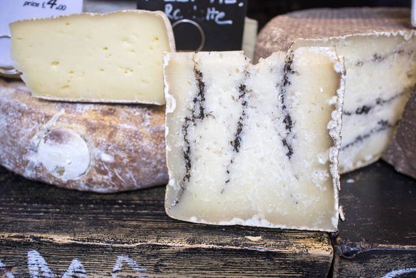 İçinde ot olan keçi peyniri. Çiftçi pazarında satılık. - Fotoğraf, Görsel
