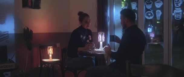 Młoda para rozmawia i pije kawę w kawiarni - Materiał filmowy, wideo