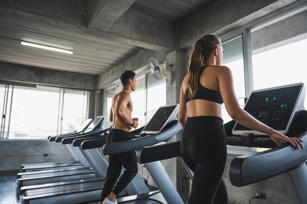 Man and woman Exercising by running on the treadmill To maintain good health always - Valokuva, kuva