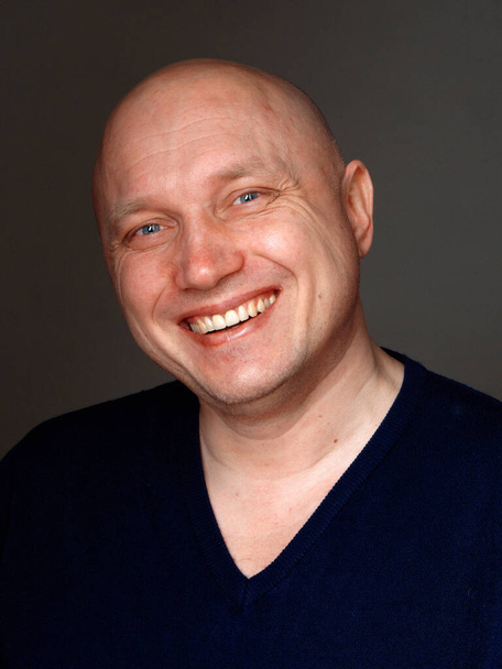 Porträt eines glatzköpfigen, fröhlichen Mannes auf schwarzem Hintergrund 2020 - Foto, Bild
