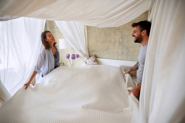 Young happy couple in the morning cover canopy bed - Foto, Bild