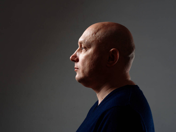 Portrait of a bald cheerful man in profile on a black background 2020 - Фото, зображення