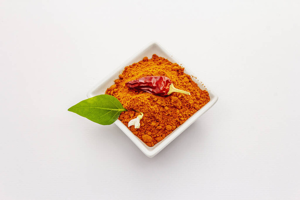 Hungarian hot paprika powder isolated on white background. Traditional seasoning in ceramic plate - Photo, Image