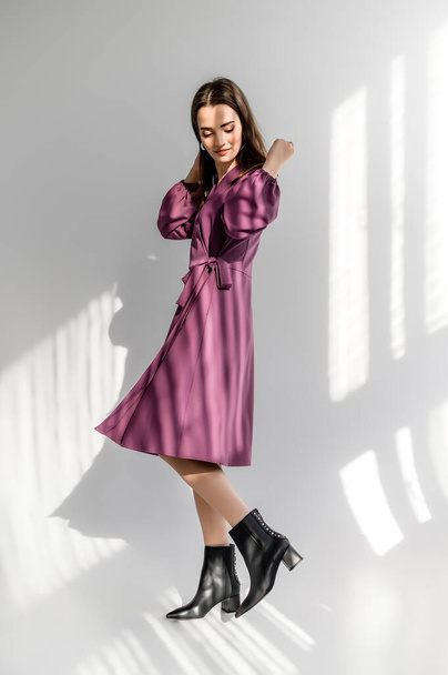 Attractive brown-haired woman in a purple checkered dress on a white background. Photosession for a clothing catalog - Foto, immagini