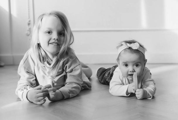 Two cute sisters close to each other and playing at home. - Fotografie, Obrázek
