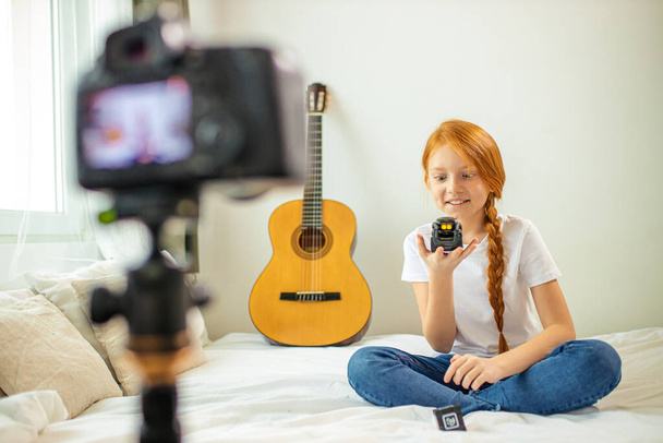 positive caucasian girl show new device at camera - Zdjęcie, obraz