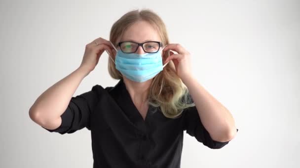protezione contro il coronavirus. donna mette una maschera sul suo viso
. - Filmati, video