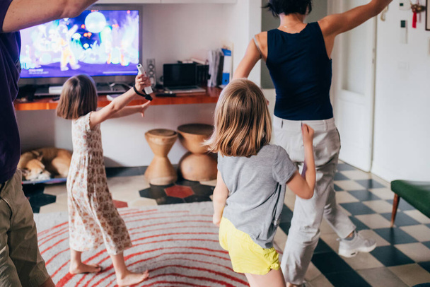 Perhe tanssia yhdessä sisätiloissa videopeli - terveellistä elämäntapaa, yhdessä, pelikonsepti
 - Valokuva, kuva