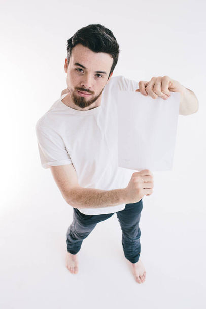 Bearded man holding a blank white sheet of paper - Fotó, kép