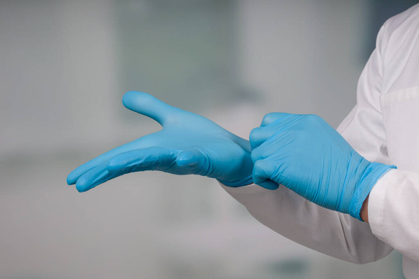 primer plano de la mano del médico en guantes médicos frente a una sala de la clínica
 - Foto, Imagen